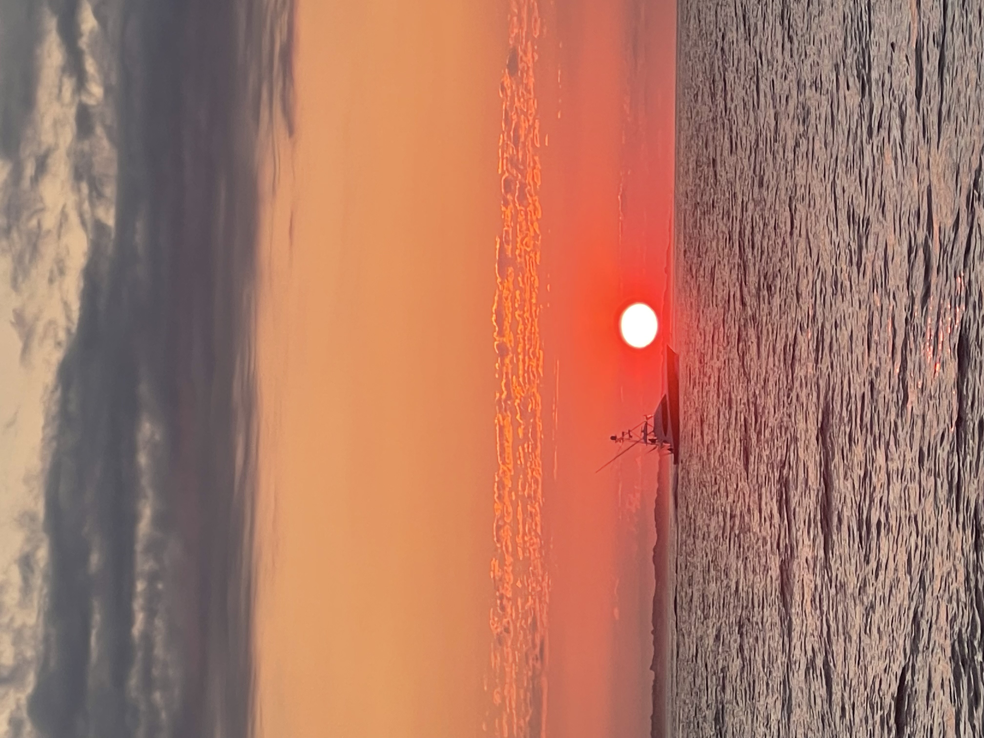 Fishing boat passing the setting sun off the East End